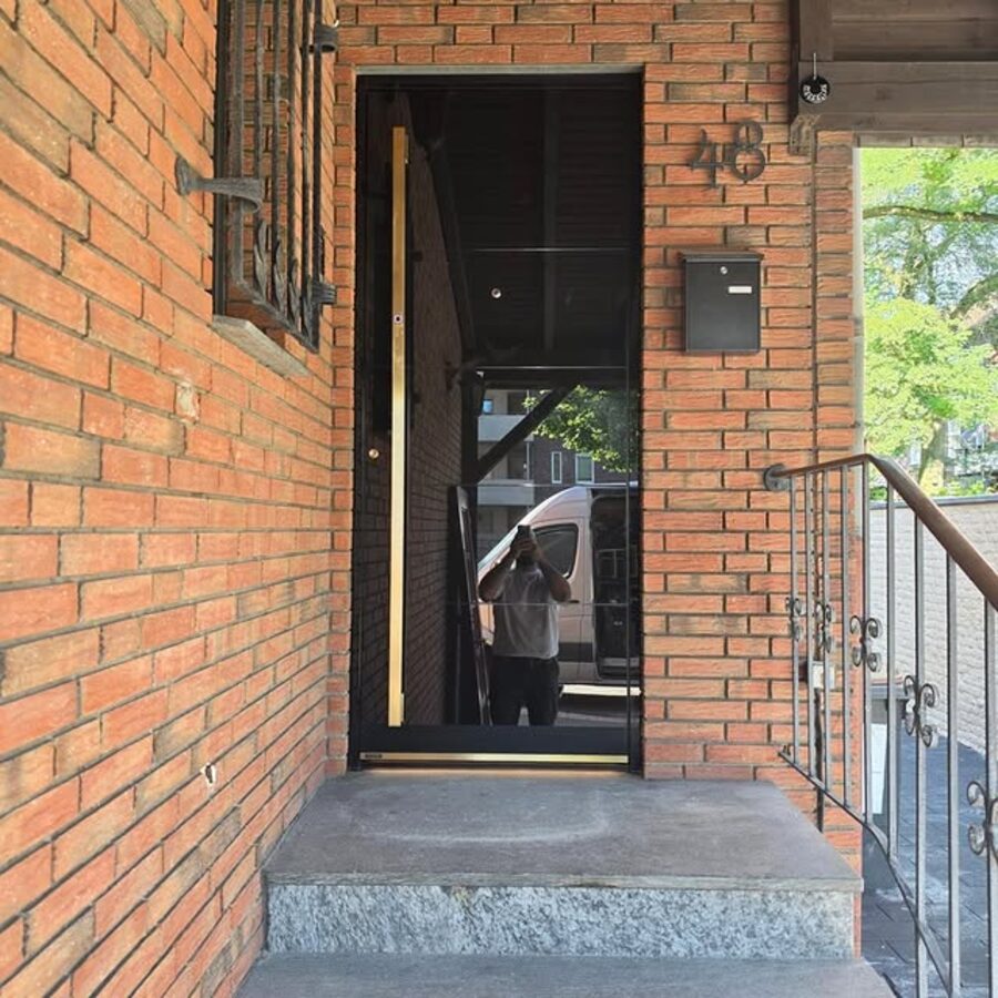 Moderne dunkle Haustür mit Fingerprint an einem Hauseingang mit Treppe
